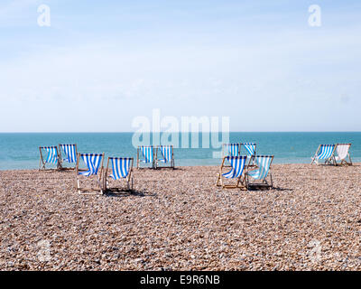 Blu e bianco sedie a sdraio sulla spiaggia di Brighton, East Sussex, Regno Unito Foto Stock