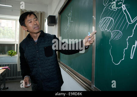 (141101) -- YINCHUAN, nov. 1, 2014 (Xinhua) -- Wang Boming discute la diffusione del virus Ebola utilizzando una mappa del mondo che egli ha riportato durante una geografia di classe a Yingcai Junior High School di Yinchuan, capitale del nord-ovest della Cina di Ningxia Hui Regione autonoma, il 31 ottobre 2014. Wang Boming usato per essere un insegnante di arti, ma ora insegna geografia presso Yingcai Junior High School di Yinchuan. Durante la sua classe, Wang può disegnare una intatta mappa del mondo sulla lavagna entro quattro minuti, che egli considera come un più diretto e coinvolgente per esporre gli studenti alla conoscenza geografica. Wang avrebbe anche breve i suoi studenti Foto Stock