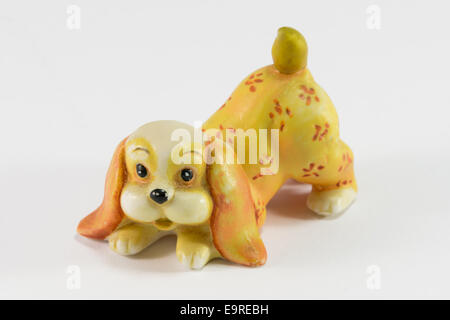 Statuetta di dog sitter su sfondo bianco, ceramica cane figurina Foto Stock