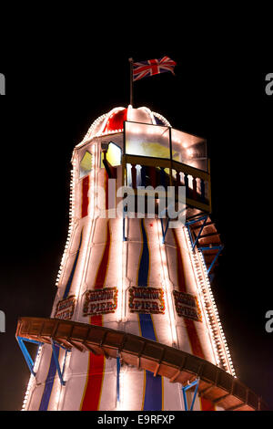 In legno Vintage Helter Skelter su Brighton il Palace Pier illuminata di notte con una unione jack volare in alto Foto Stock