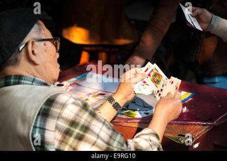 Il vecchio uomo giocando a carte, Hong Kong Foto Stock