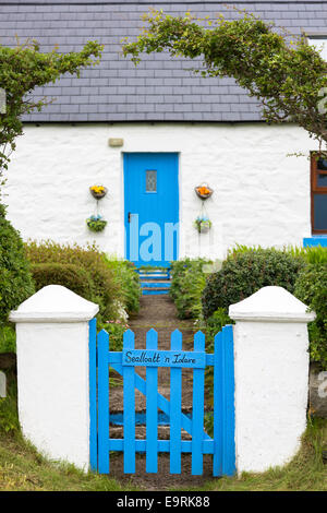 Cottage tradizionale con blue di legno verniciato della porta anteriore e del cancello, piastrelle di ardesia e giardino frontale sulla isola di Skye, la Western Isle Foto Stock