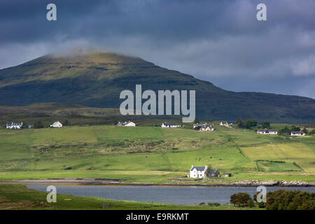 White croft cottages annidato nel borgo di montagna e Loch Vatten sotto le nuvole grigio a Roag sull'Isola di Skye, Western Isles Foto Stock