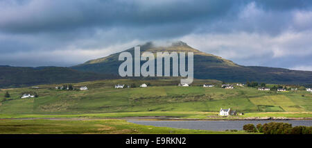 White croft cottages annidato nel borgo di montagna e Loch Vatten sotto le nuvole grigio a Roag sull'Isola di Skye, Western Isles Foto Stock