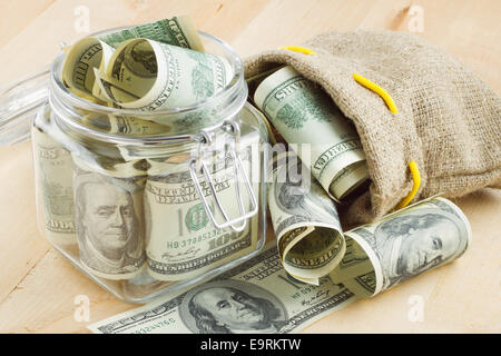 Dollar banconota in un barattolo di vetro ed il sacco di soldi Foto Stock