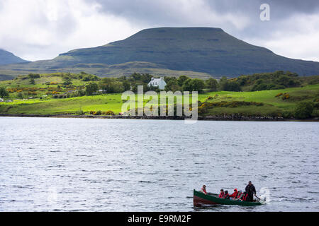 I turisti su sealwatching gita in barca presso il castello di Dunvegan loch, casa delle Highlands MacLeod del clan e MacLeod La Table Mountain, th Foto Stock