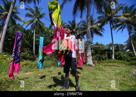 Maestro artigiano di asciugatura artigianato batik, dipinte a mano a mano sotto il sole tropicale. Foto Stock