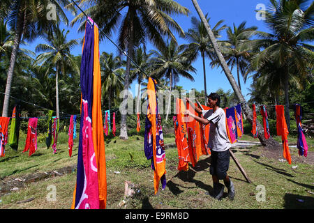 Maestro artigiano di asciugatura artigianato batik, dipinte a mano a mano sotto il sole tropicale. Foto Stock