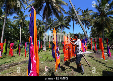 Maestro artigiano di asciugatura artigianato batik, dipinte a mano a mano sotto il sole tropicale. Foto Stock