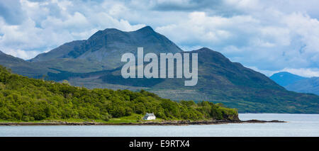 Imbiancati solitaria croft cottage attraverso il suono di Sleat con Knoydart mountain dietro, Isola di Skye,l'Ebridi Interne e Foto Stock