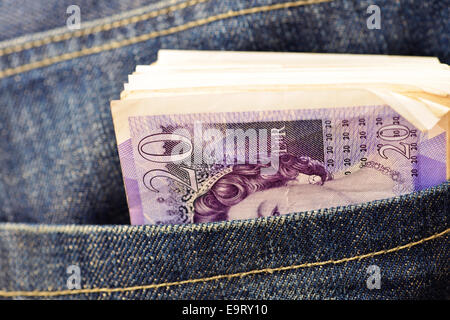 Bundle di venti pound note nella tasca posteriore dei jeans denim Foto Stock