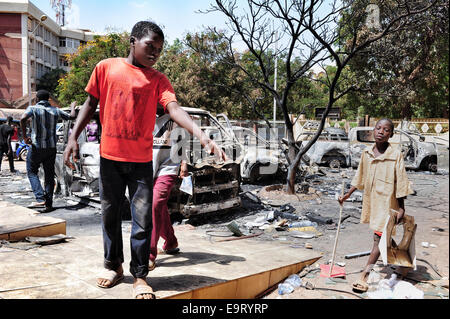 Ouagadougou, Burkina Faso. 1 Novembre, 2014. Burkina Faso - disordini politici mostra alcuni ragazzi camminare tra i detriti dalla Azalai hotel in Ouagadougou, Burkina Faso, due giorni dopo che è stato aggredito dai manifestanti come legislatori disposti a votare per consentire il presidente Blaise Compaore -- che ha preso il potere con un colpo di stato 1987 -- per contestare le elezioni nel 2015. L'hotel Azalai usato per essere uno dei più prestigiosi hotel della città. Credito: Marina Spironetti/Alamy Live News Foto Stock