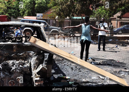 Ouagadougou, Burkina Faso. 1 Novembre, 2014. Burkina Faso - disordini politici mostra una signora avente la sua foto prese da alcuni incendiate automobili dalla Azalai hotel in Ouagadougou, Burkina Faso, due giorni dopo che è stato aggredito dai manifestanti come legislatori disposti a votare per consentire il presidente Blaise Compaore -- che ha preso il potere con un colpo di stato 1987 -- per contestare le elezioni nel 2015. L'hotel Azalai usato per essere uno dei più prestigiosi hotel della città. Credito: Marina Spironetti/Alamy Live News Foto Stock