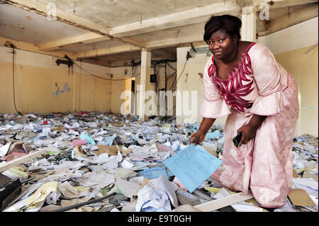 Ouagadougou, Burkina Faso. 1 Novembre, 2014. Burkina Faso - disordini politici mostra una signora cercando tra i detriti all'interno di quello che è a sinistra di una banca banca nel centro di Ouagadougou, due giorni dopo fu saccheggiata dai manifestanti come legislatori disposti a votare per consentire il presidente Blaise Compaore -- che ha preso il potere con un colpo di stato 1987 -- per contestare le elezioni nel 2015. Credito: Marina Spironetti/Alamy Live News Foto Stock