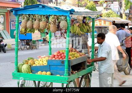 POKHARA, Nepal - 11 ottobre: venditore locale con una carrellata di stallo in legno schiaccia frutti vende un succo di frutta per le persone di passaggio - Foto Stock