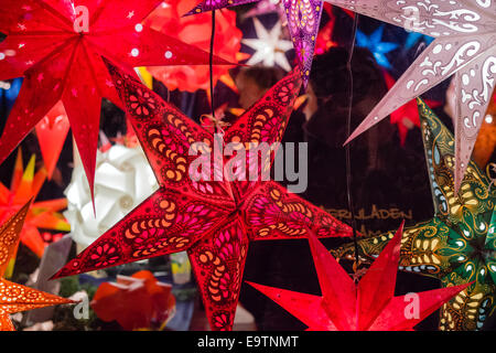 Festive a forma di stella lanterne di carta per la vendita in un tedesco mercatino di Natale Foto Stock