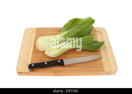 Cavolo cinese pak choi, su una scheda di bambù con un coltello isolata contro bianco Foto Stock