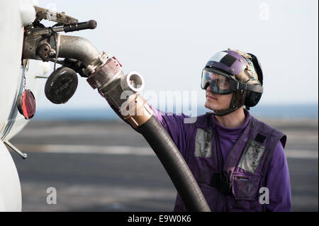 Stati Uniti Aviazione Navale di Boatswain Mate (combustibili) Airman Jared combustibili Kampschroeder un F/A-18C Hornet aeromobile assegnati allo sciopero lotta Foto Stock