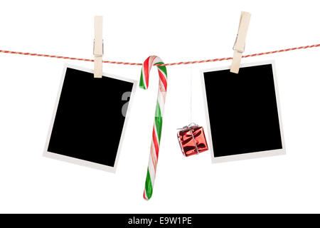 Fustellato cornici fotografiche e candy cane appeso sul stendibiancheria. Isolato su sfondo bianco Foto Stock