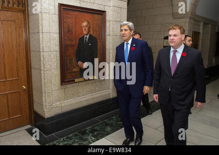 Stati Uniti Il segretario di Stato John Kerry e il Ministro degli esteri canadese John Baird passare un ritratto dell ex Primo Ministro Brian Mulroney come loro due preparare a lasciare la Collina del Parlamento di Ottawa in Canada, il 28 ottobre 2014, dopo che il segretario ha visitato a pagare con Foto Stock