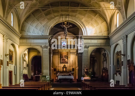 La Chiesa dell'Assunzione della Vergine Maria nel piccolo villaggio di Dozza vicino a Bologna in Emilia Romagna: interni: Croce, altare, scrivanie, panchine, dipinti, candele Foto Stock