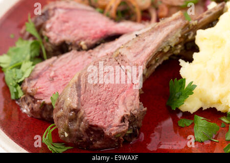 Costolette di agnello tagliato da un arrosto di agnello rack e servita con crema di patate all'aglio e cipolla relish Foto Stock