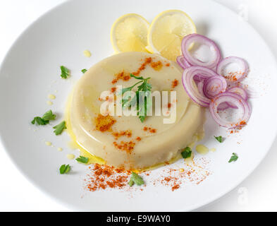 Un paté di stampati essiccato turco fava purea, guarnita con limone, cipolla, peperoncino e prezzemolo, kuru bakla ezmesi Foto Stock