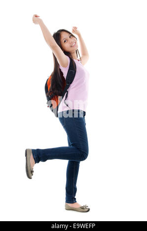 A piena lunghezza pan Asian teen studente tifo con bracci sollevati, isolati su sfondo bianco. Foto Stock