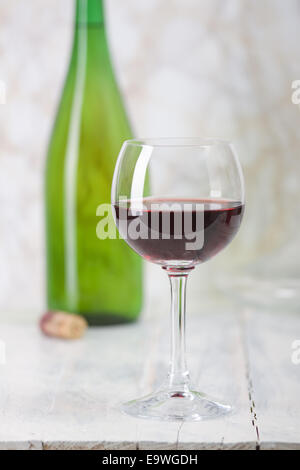 Il vino rosso è versata da una bottiglia in un bicchiere. Foto Stock