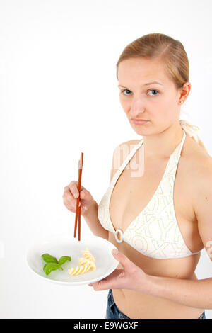 Giovane donna prende un estremamente piccola porzione di cibo Foto Stock