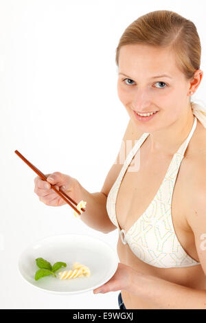 Giovane donna prende un estremamente piccola porzione di cibo Foto Stock