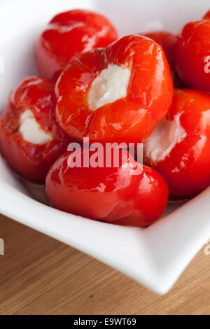 La ciliegia peperoni ripieni di formaggio cremoso in olio di oliva. Foto Stock