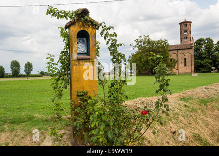 Edicola votiva dedicata alla Beata Vergine Maria vicino alla campagna medievale chiesa di campanile romanico con campanile cilindrico, situato nel villaggio di Santa Maria in Fabriago in Emilia Romagna regione del nord Italia Foto Stock