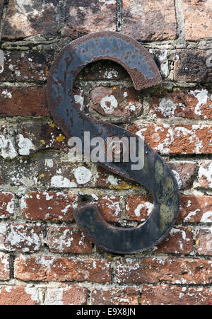S a forma di asta di rinforzo estremità supportante il deterioramento di una vecchia red muro di mattoni Foto Stock