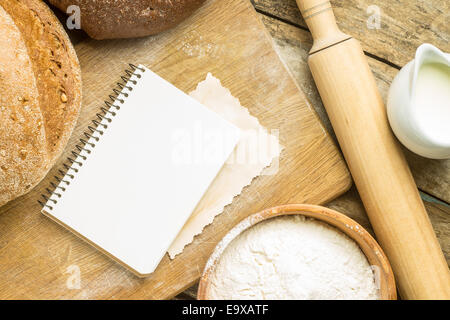 Lo sfondo del menu. Bakery Ingredients con ricetta vuota libro sul tavolo di legno Foto Stock