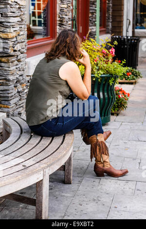 Una donna che indossa un paio di stivali da cowboy e jeans blu Foto Stock