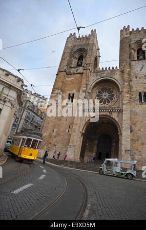 Streetview verticale del tradizionale giallo il tram di fronte la Cattedrale di Lisbona. Foto Stock