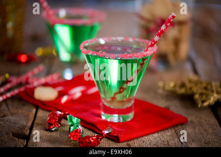 Natale verde smeraldo cocktail, bordati di vetro frantumato con candy cane. Ottimi drink per intrattenimento. Foto Stock