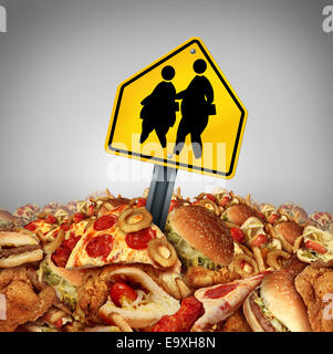 Bambini i problemi di dieta e obesità in crisi il concetto di scuola come un mucchio di malsana fast food con due sovrappeso grasso bambini su un traffico di attraversamento di segno come un rischio nutrizionale simbolo per la gioventù. Foto Stock