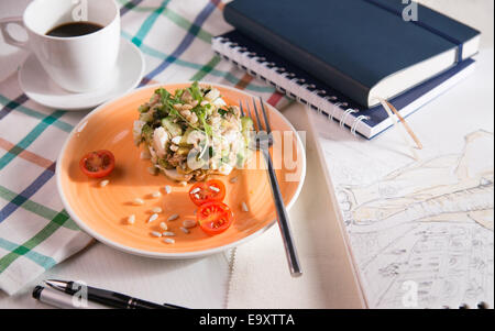 Insalata russa per la colazione su un panno a scacchi e taccuini Foto Stock