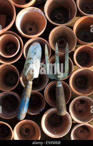 Giardino cazzuola a mano e forcella su cotto antico dei POT del fiore Foto Stock