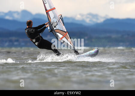 Un surfista gare sopra le onde in un vento forte sul Lago di Costanza in Fischbach, Germania, 04 novembre 2014. Anche subito dopo il tramonto, il 18 grado temperature e vento Favonio è il disegno surfers e il Lago di Costanza sul confine tedesco in Svizzera. Foto: FELIX KAESTLE/dpa Foto Stock