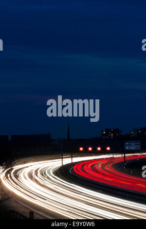 Auto di notte su una autostrada. Luci di corda e insegne luminose Foto Stock