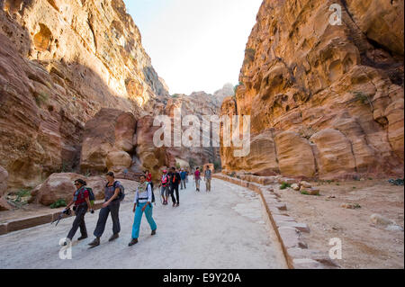 I turisti sono a piedi attraverso "Siq"."Il Siq' è una stretta gola che conduce i visitatori in Petra in Giordania Foto Stock