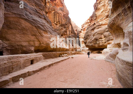 I turisti sono a piedi attraverso "Siq"."Il Siq' è una stretta gola che conduce i visitatori in Petra in Giordania Foto Stock