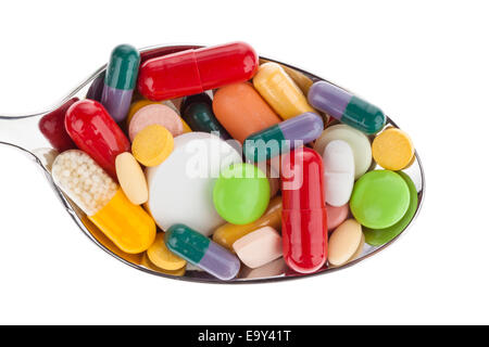 Molte diverse compresse di colore su un cucchiaio. Abuso di droghe. Isolato su sfondo bianco. Foto Stock