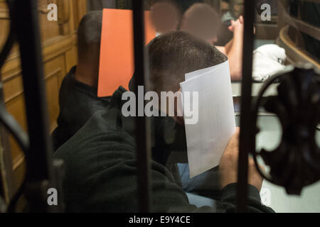 Berlin-Moabit, Germania. 04 Nov, 2014. Defendent Cenkay T. (F) si copre il viso con un foglio di carta sul dock in aula presso il tribunale penale di Berlin-Moabit, Germania, 04 novembre 2014. La prova inizia martedì contro undici bikers che sono incaricati di uccidere un 26-anno-vecchio uomo in un agenti di scommesse a Berlino nel gennaio del. Foto: Matthias esitano di fronte/dpa/Alamy Live News Foto Stock