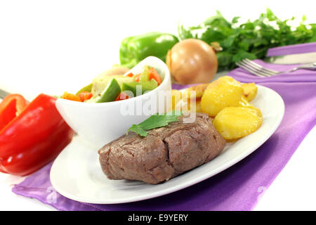 Arrosto bistecche di carne di struzzo con patate al forno su sfondo lucido Foto Stock