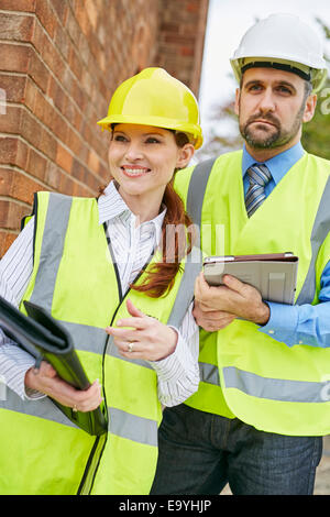 Gli architetti per discutere i piani in un sito di costruzione Foto Stock