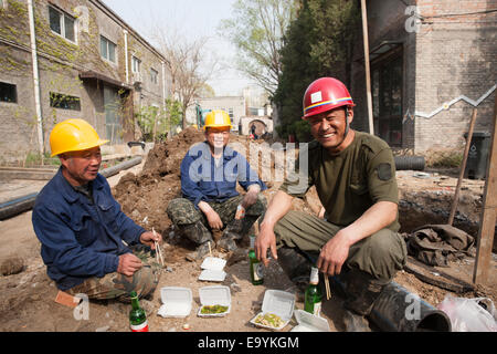 Lavoratori edili di mangiare il pranzo Foto Stock